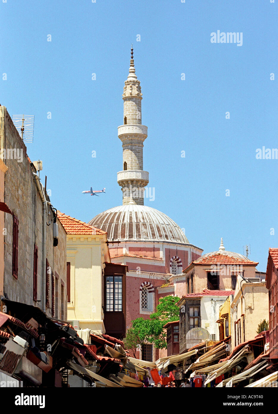 Via dello shopping, la Moschea e minareto nella città vecchia di Rodi con aereo di linea jet nel cielo Foto Stock