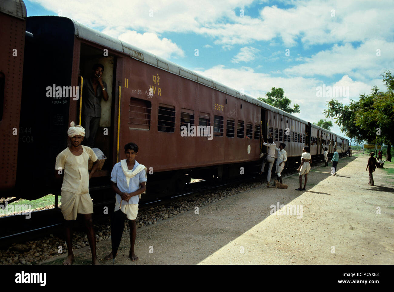 India due uomini stavano in piedi fino in prossimità di un treno fermo in una stazione ferroviaria Tra Bombay e Udaipur Foto Stock