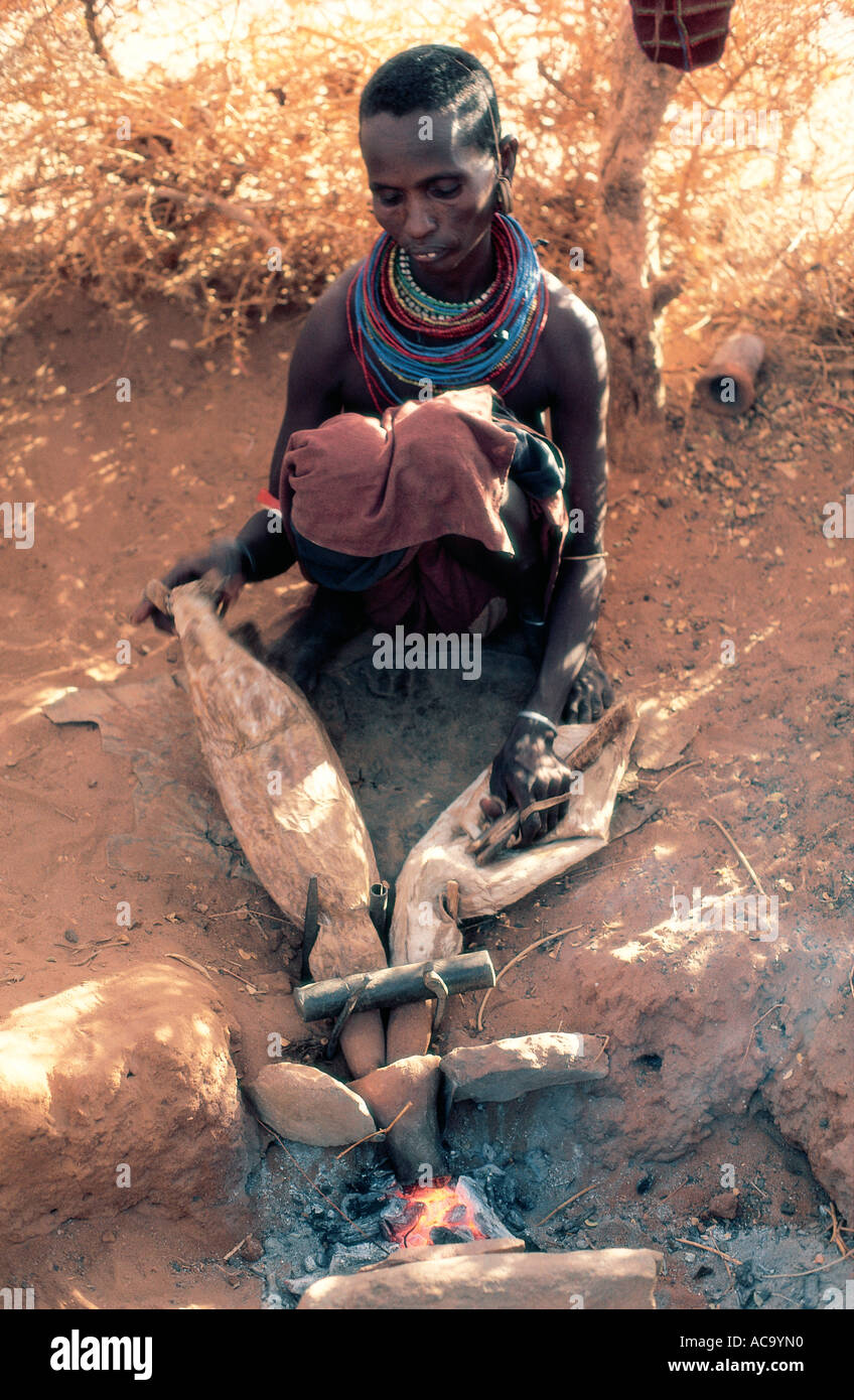 La moglie del fabbro Rendille pompe aria con pelle di capra il soffietto sul fuoco Korr Kenya Settentrionale Africa orientale Foto Stock