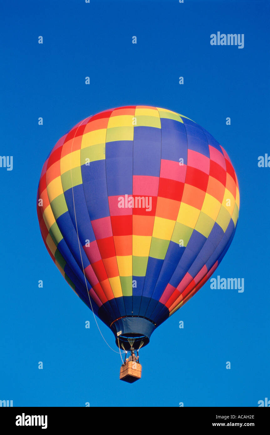 Multicolorata mongolfiera con cestello in cielo blu decollare sollevare Foto Stock