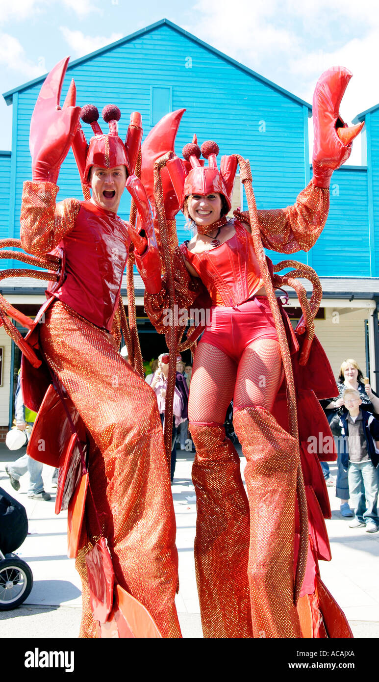 Il carnevale di ballerini astici giganti Claude e Lucia di pali verticali di eseguire a Fleetwood freeport carnevale Foto Stock