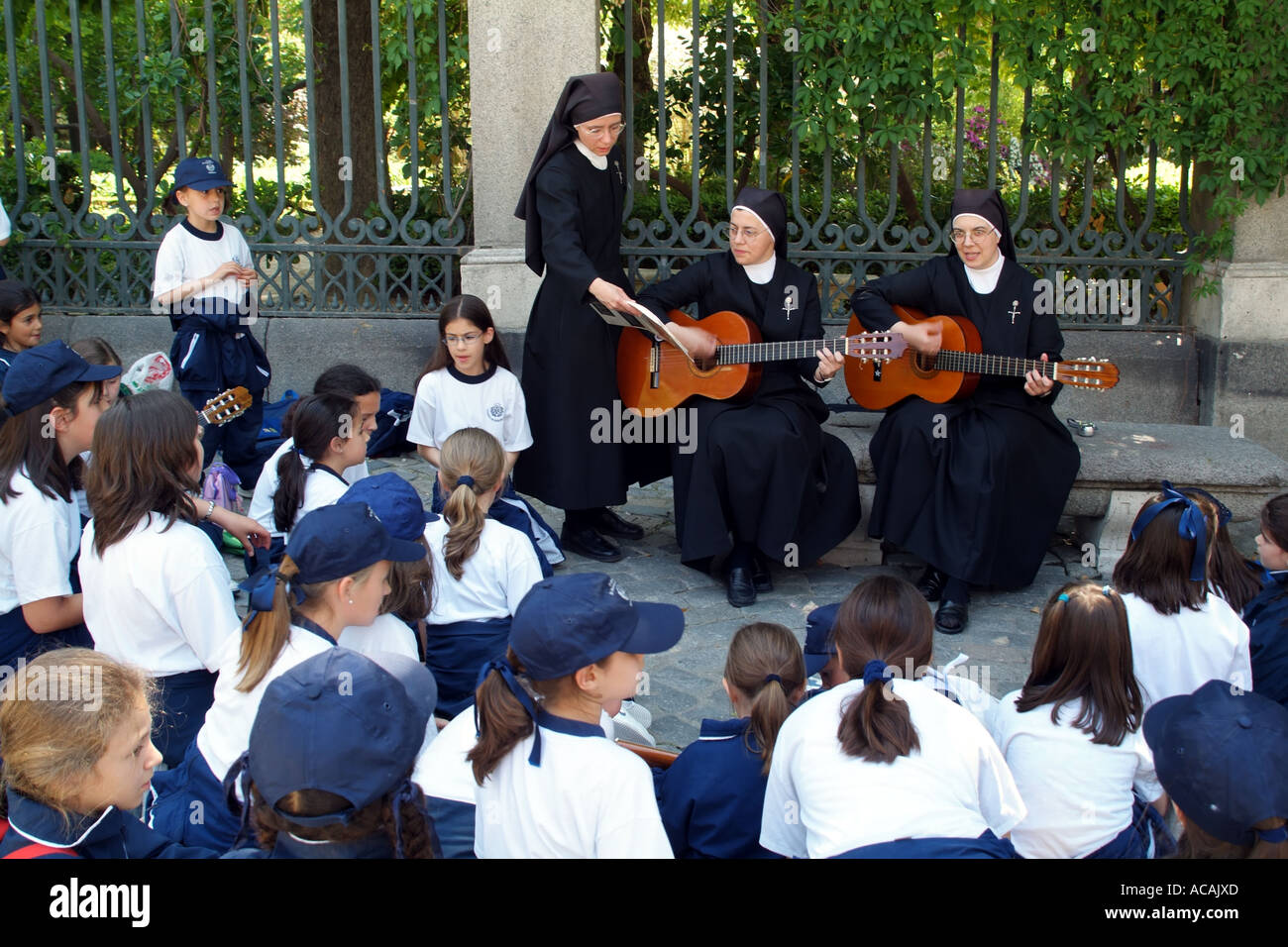 Scolari essendo intrattenuti da suonare la chitarra cantando le monache. Madrid capitale della Spagna Europa UE Foto Stock