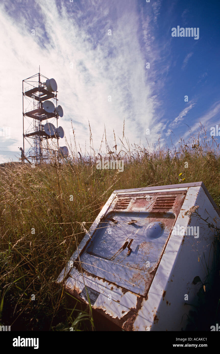 Il campo di ribaltamento con il montante del telefono cellulare e il frigorifero gettato formano un'imboscata e un pericolo in un paesaggio di campagna Foto Stock