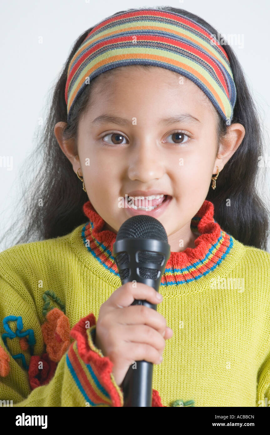 Close-up di una ragazza cantare di fronte a un microfono Foto Stock