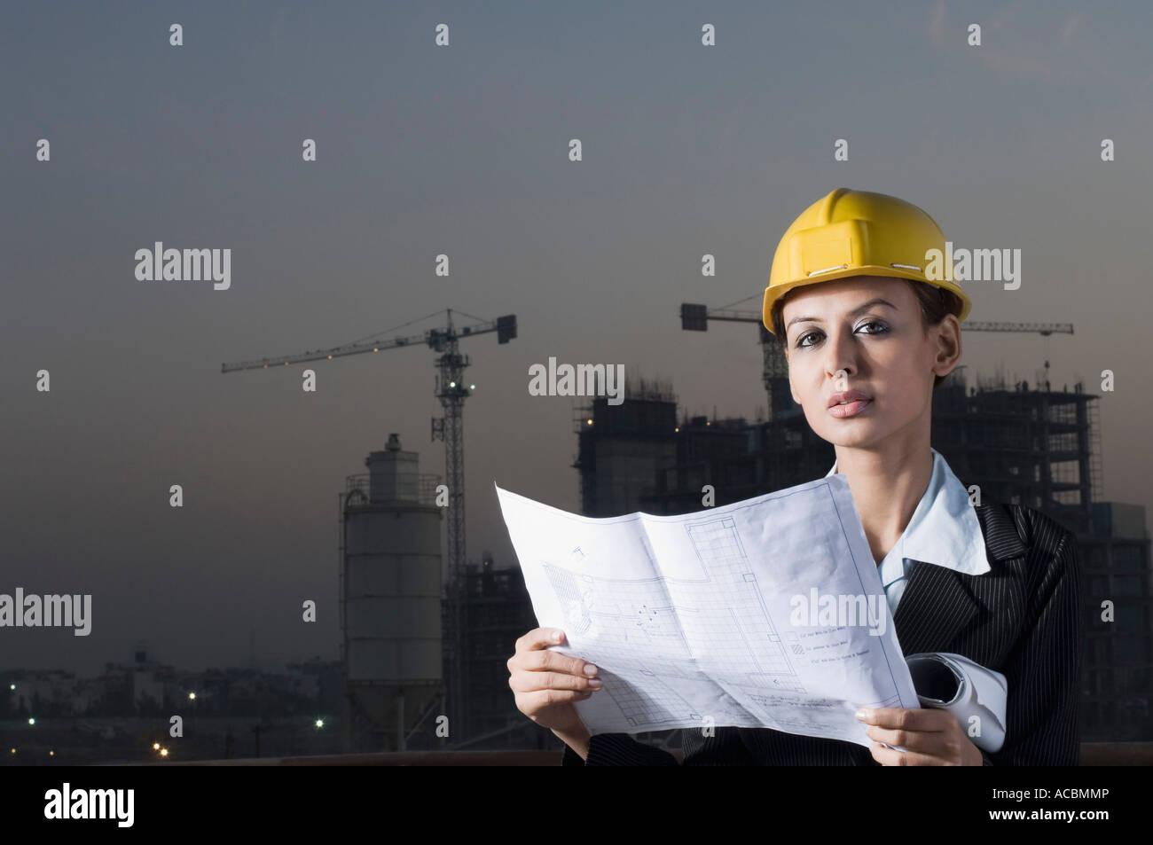 Ritratto di una imprenditrice che indossa un casco e tenendo un blueprint Foto Stock