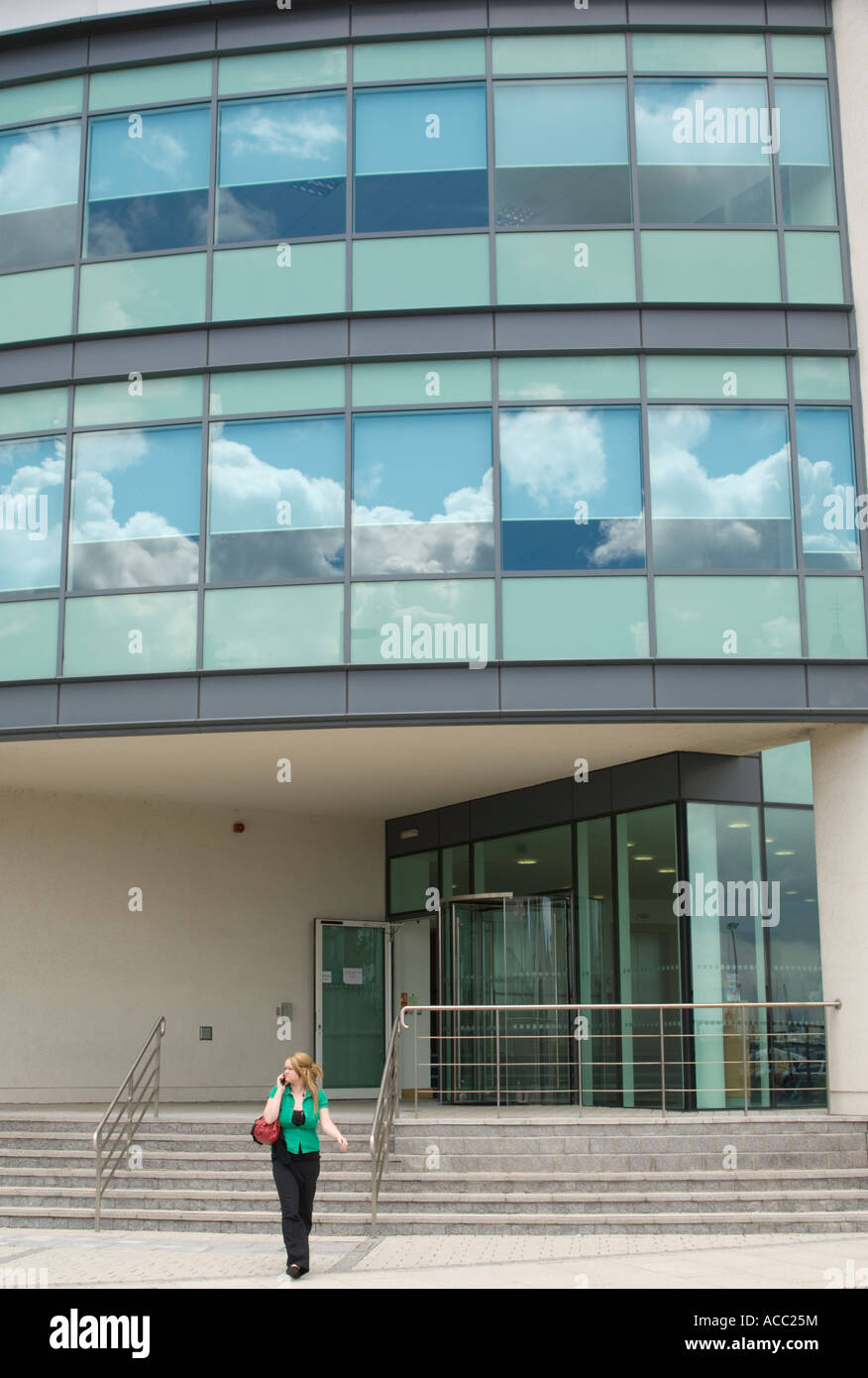 Swansea SA1 donna di sviluppo sul telefono cellulare al di fuori del nuovo costruito office block Foto Stock