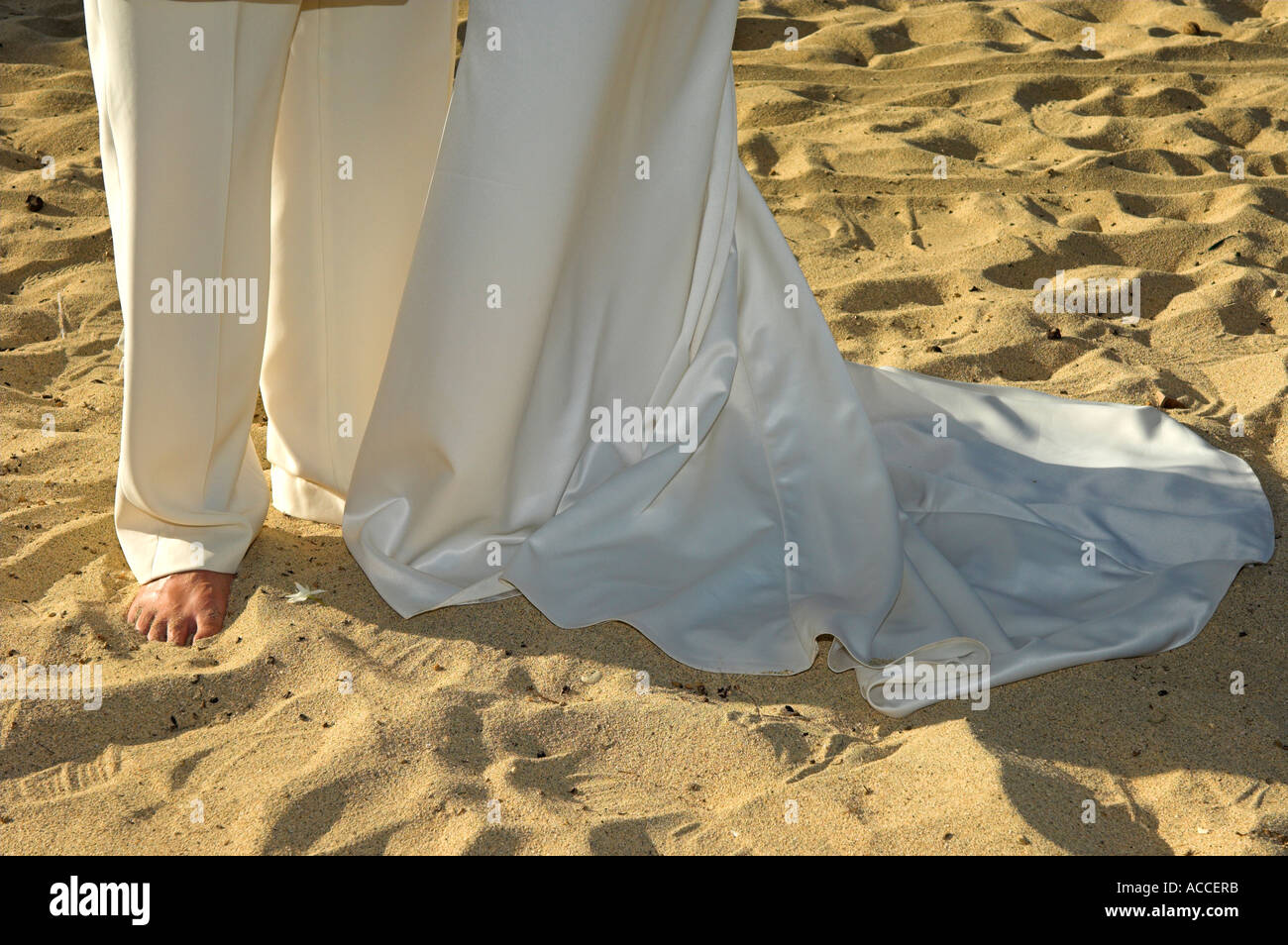 Sposa e lo sposo a piedi di nozze nella calda sabbia dorata sulla spiaggia nel tardo pomeriggio Foto Stock