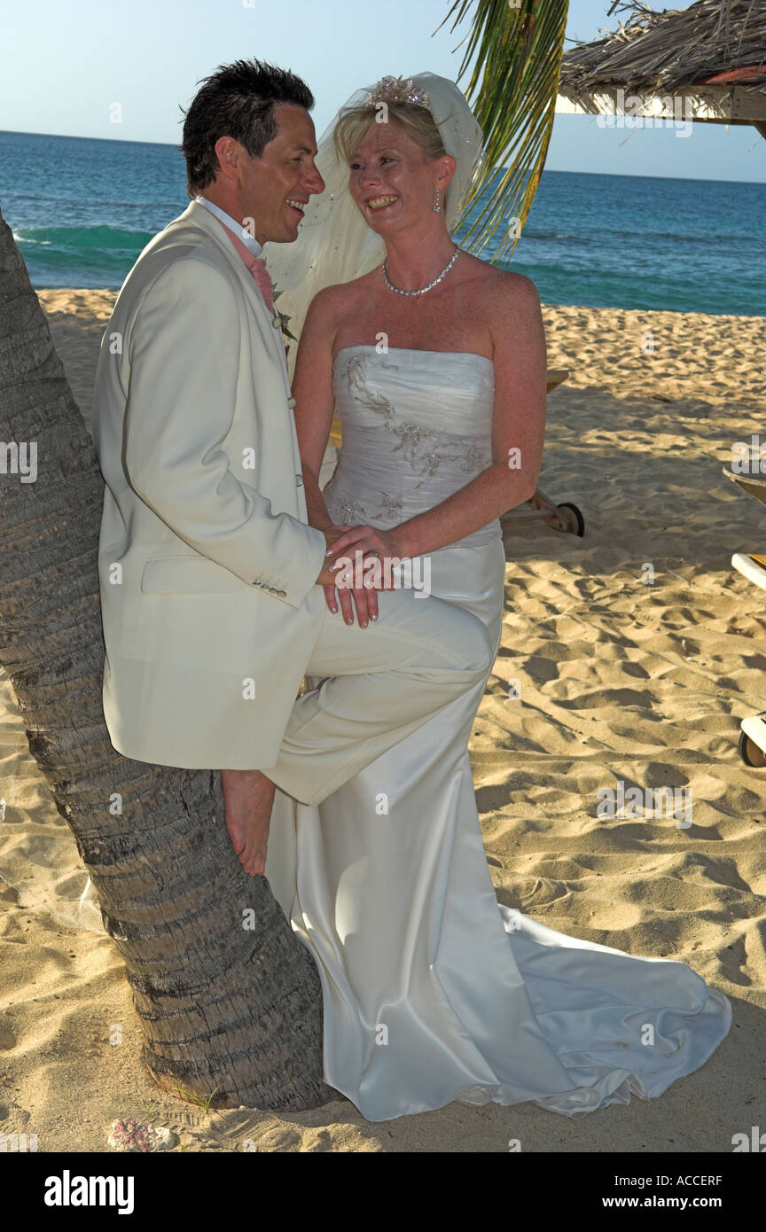 Sposa e lo sposo a piedi di nozze nella calda sabbia dorata sulla spiaggia nel tardo pomeriggio Foto Stock