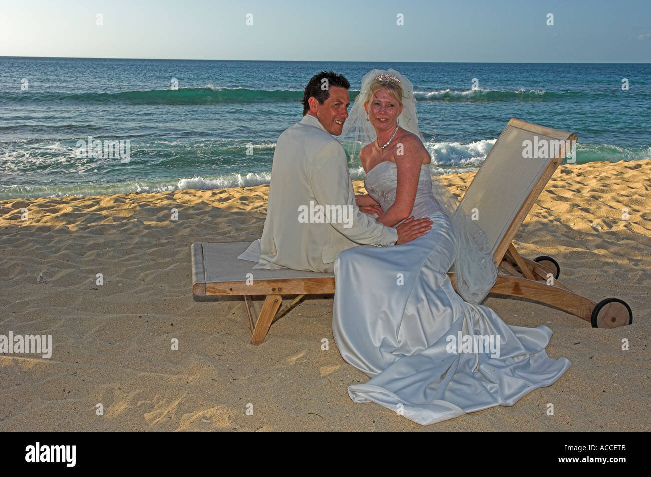 Sposa e lo sposo ad un matrimonio lounge caldo oro sabbia sulla spiaggia nel tardo pomeriggio Foto Stock
