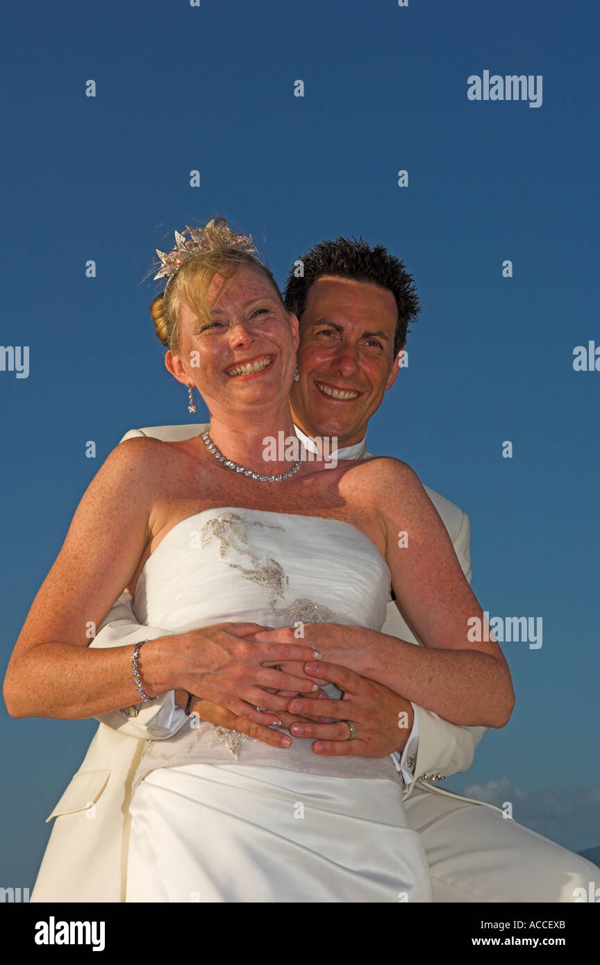 Lo sposo holding sposa su caldo tardo pomeriggio Foto Stock
