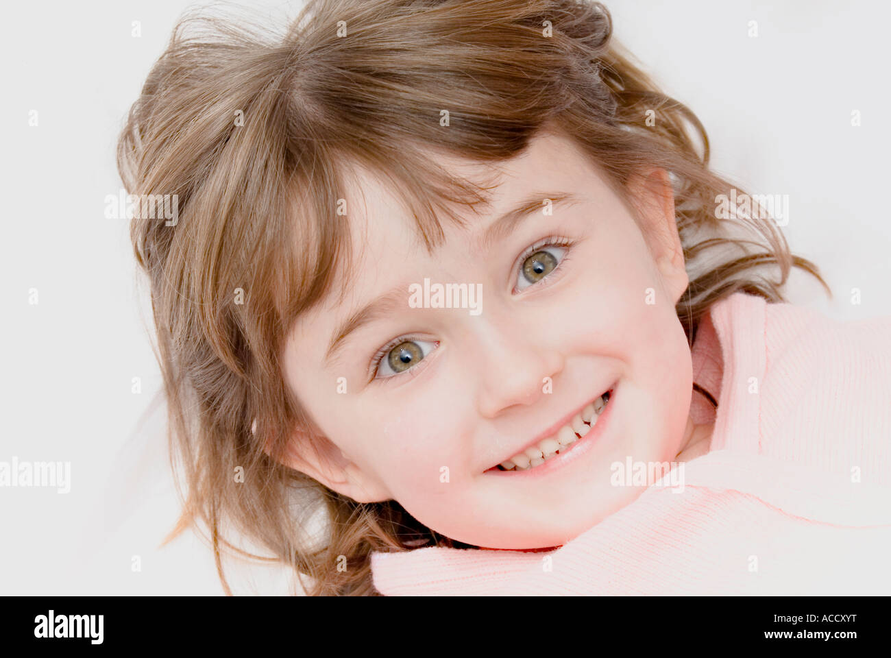 Bambina di cinque anni la posa su un fondo bianco con i suoi capelli sparsi Foto Stock
