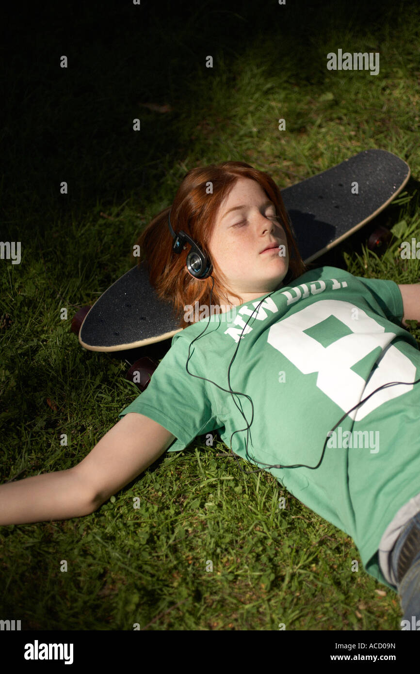 Un ragazzo in appoggio su uno skateboard. Foto Stock