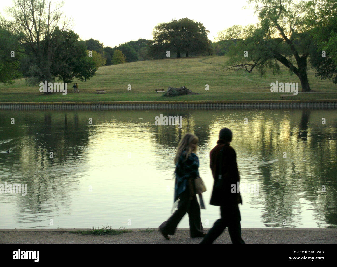 Giovane passeggiate nel parco accanto al laghetto su Hampstead Heath Foto Stock