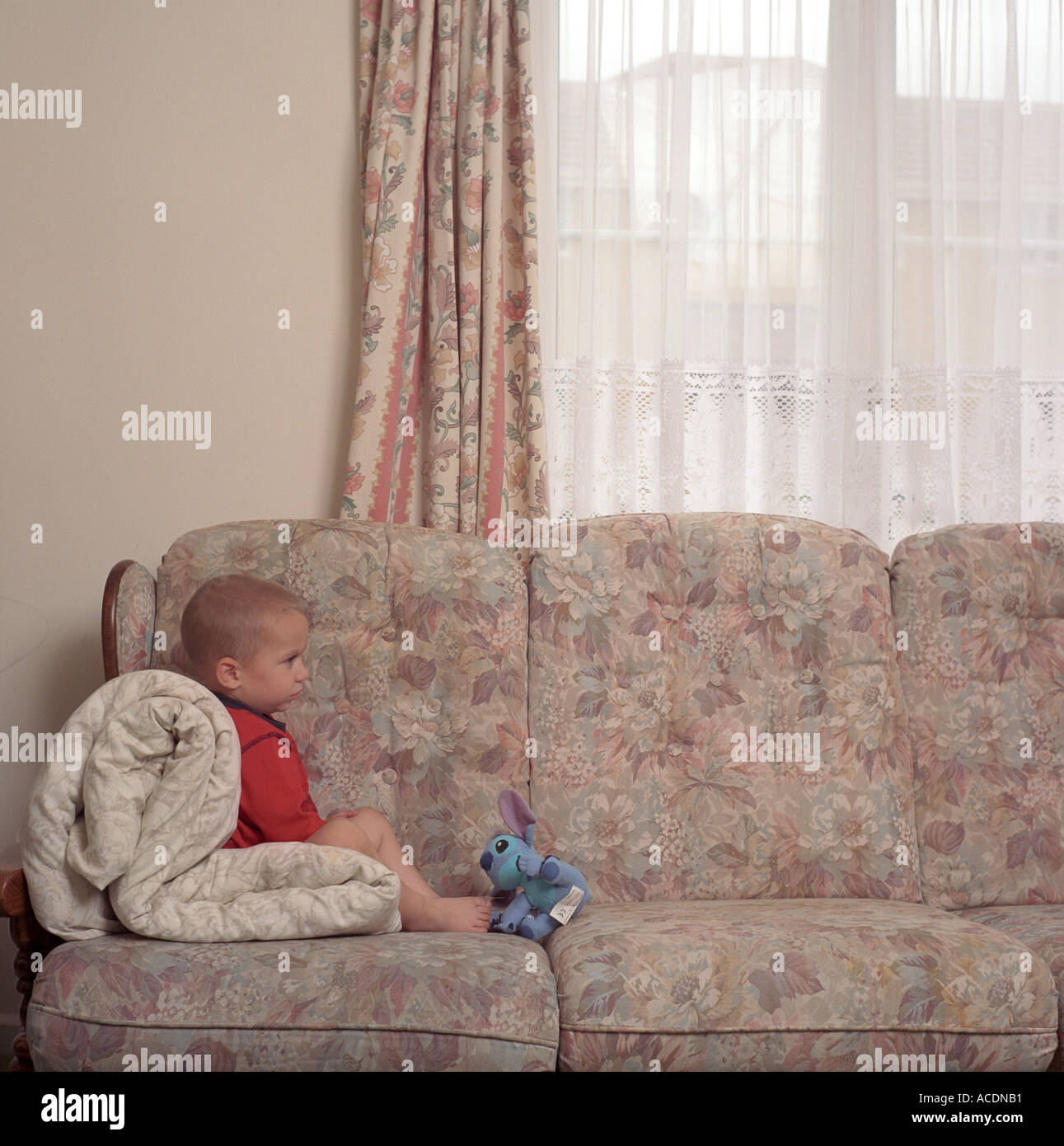 Un giovane ragazzo orologi TV seduti sul divano, Bristol, Regno Unito. Foto Stock