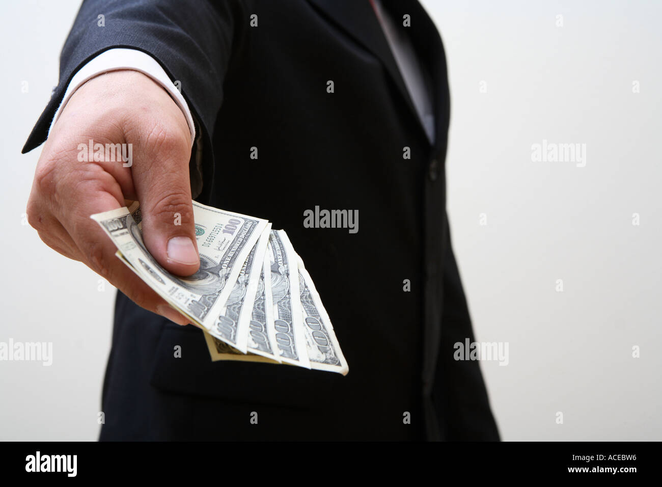 Imprenditore tenendo fuori manciata di denaro Foto Stock