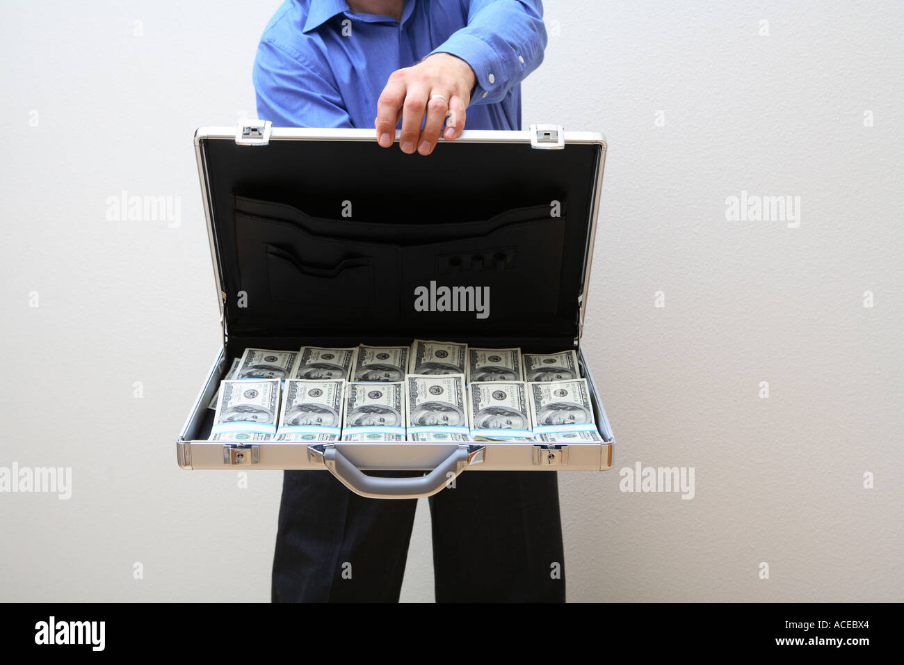 Uomo con valigetta aperta piena di denaro Foto Stock