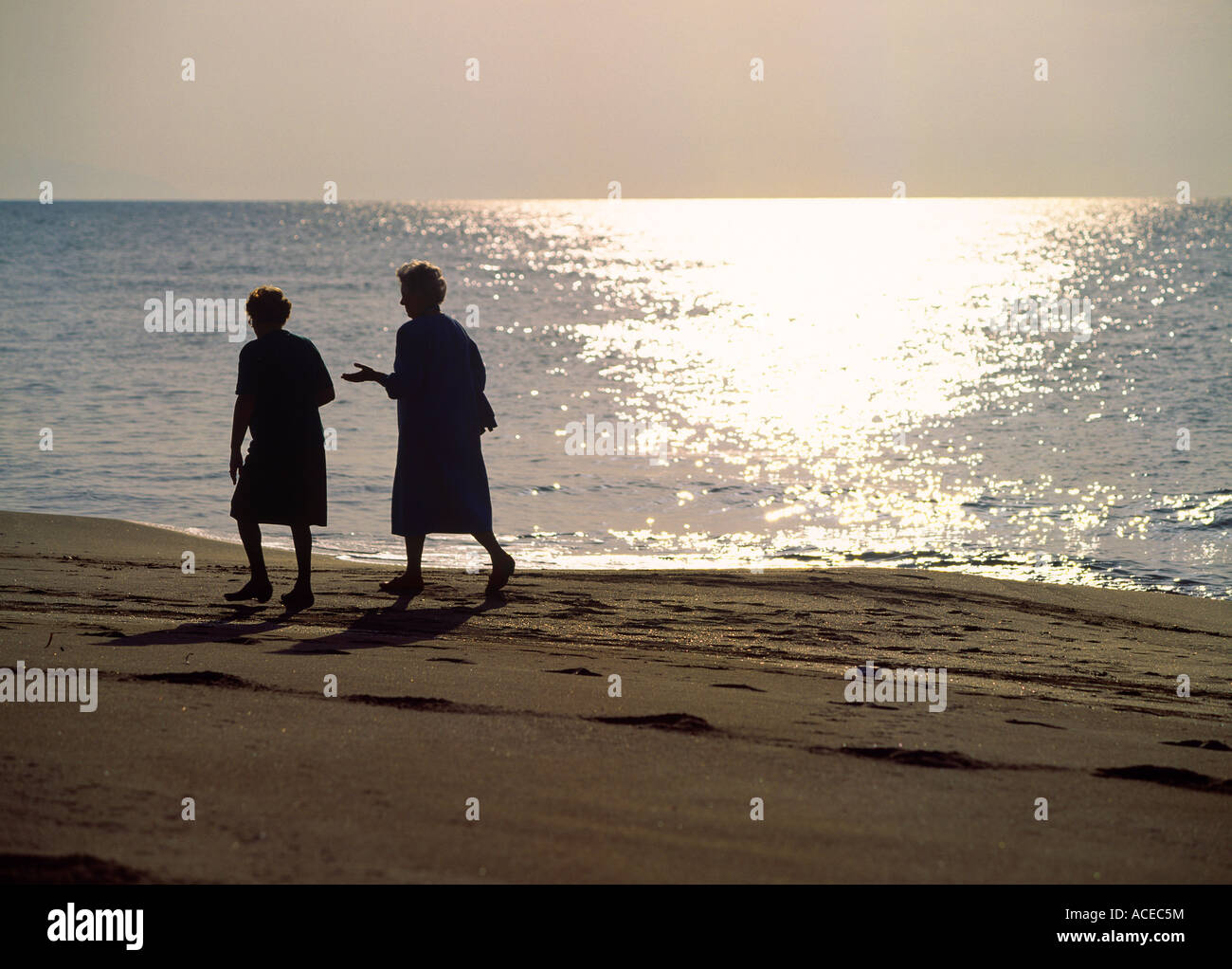 Anziani pensionati ladies a piedi la spiaggia di sera resort di san vincenzo regione toscana italia Foto Stock