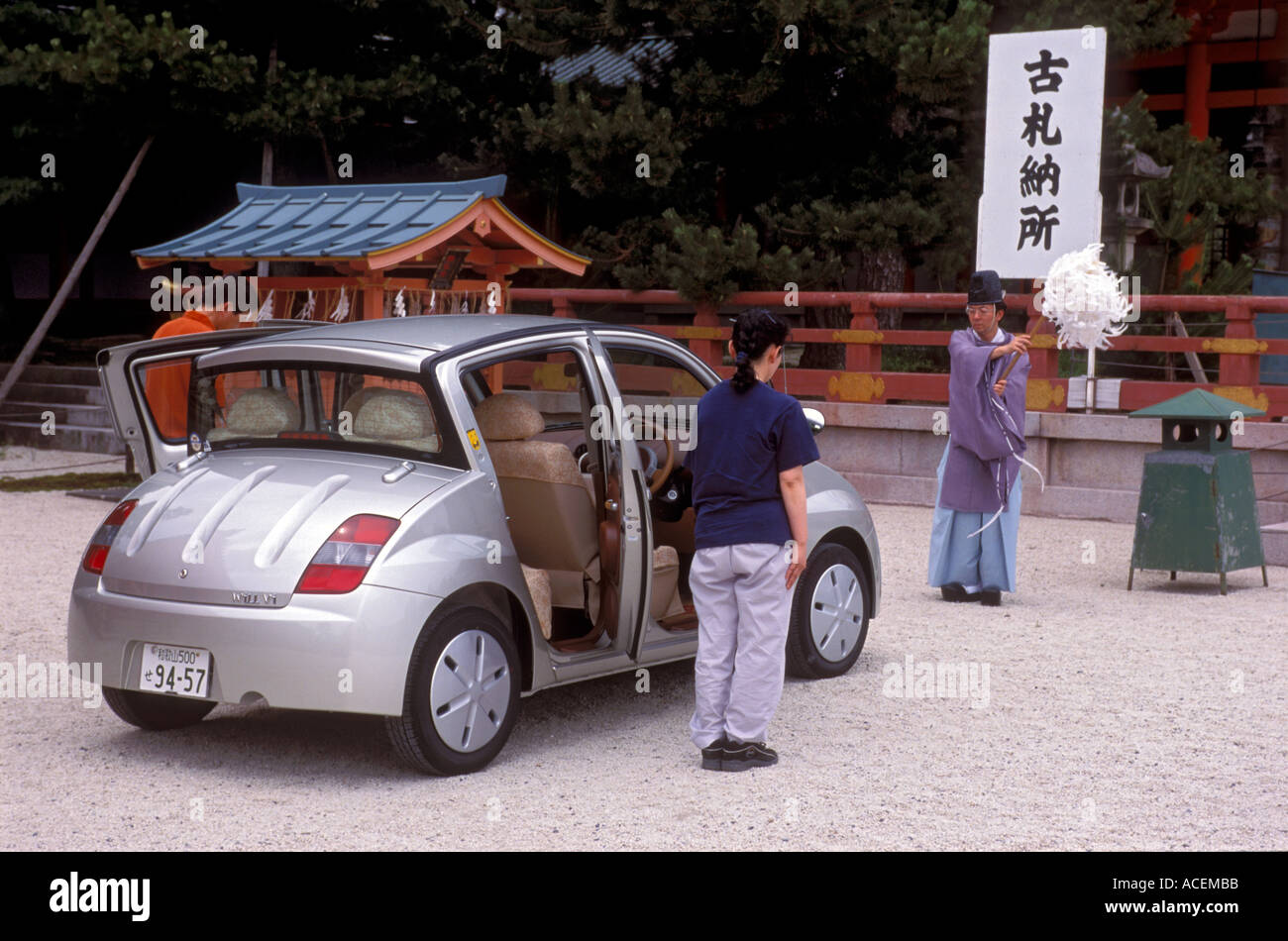 La giovane coppia che avrà la sua nuova Toyota sarà un'auto benedetta dal sacerdote shintoista al santuario Heian Jingu per liberarla dagli spiriti maligni a Kyoto, in Giappone. Foto Stock