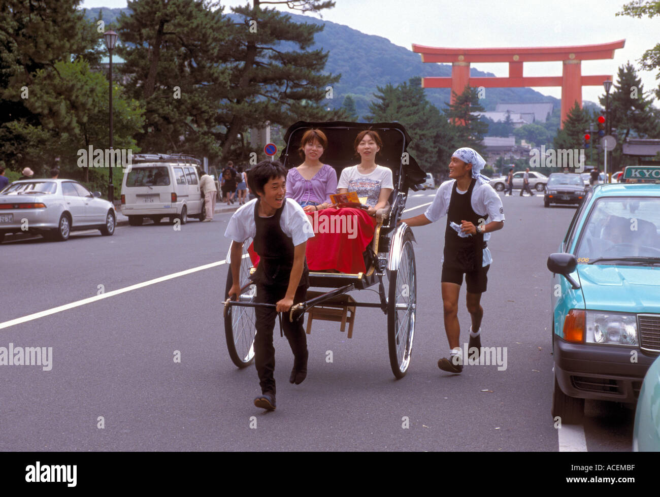 Il risciò Jinrikisha sta facendo un ritorno in Giappone perché attrae turisti come questi che visitano Kyoto, in Giappone vicino al santuario di Heian Jingu. Foto Stock