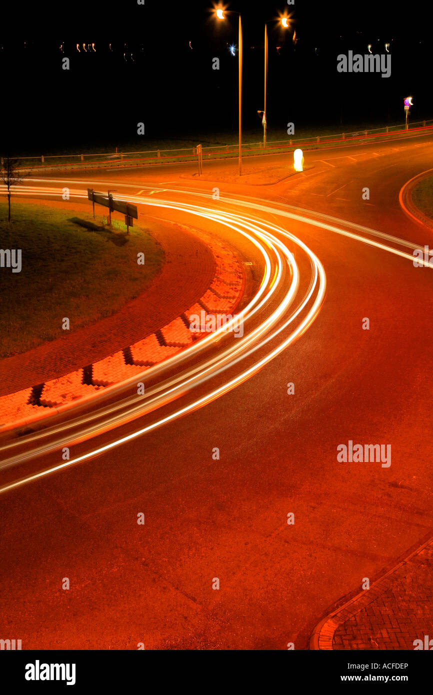 Accelerare i percorsi di luce dal traffico su una strada trafficata di notte, strade generico, autostrada rotonda Foto Stock