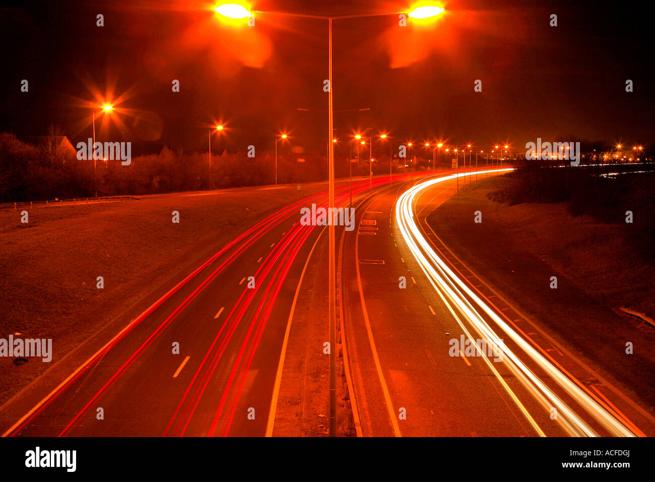 Accelerare i percorsi di luce dal traffico su una strada trafficata di notte, strade generico, autostrada Foto Stock