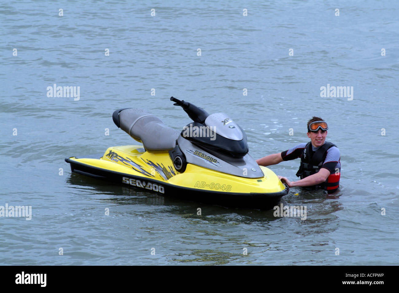 Jet Ski boat seadoo con ragazzo che indossa la vita delle attrezzature che consentono un risparmio di acqua di Southampton England Regno Unito Foto Stock