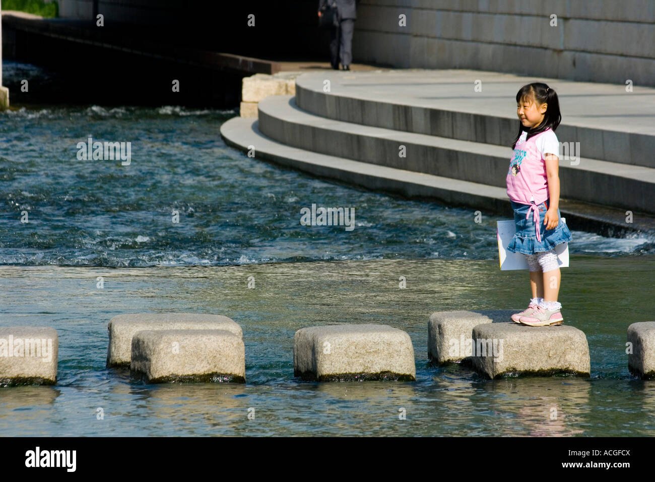 Giovane ragazza coreana attraversando Cheonggyecheon o flusso Cheonggye Seoul COREA DEL SUD Foto Stock