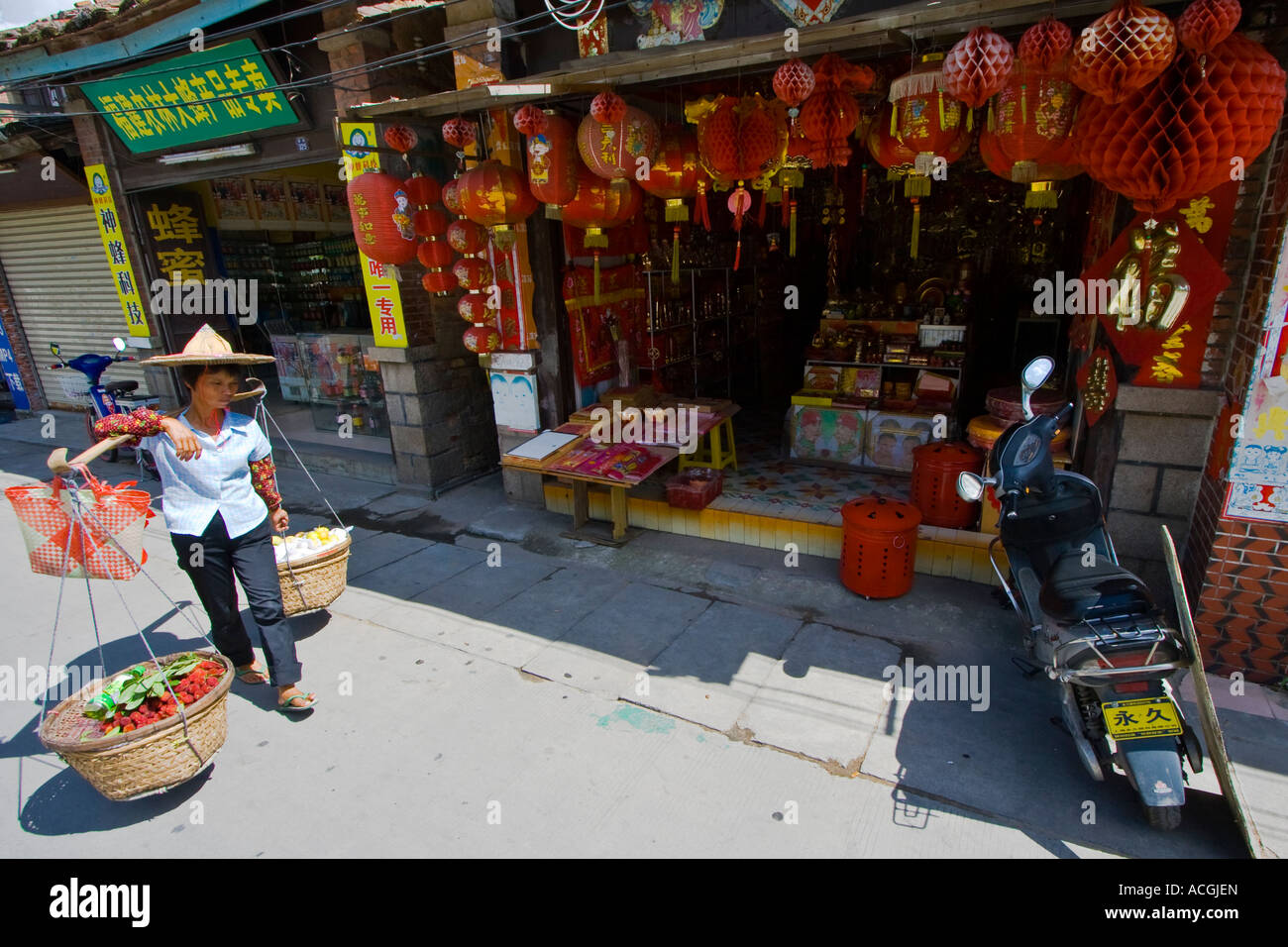 Donna che trasportano cesti di frutta sulle sue spalle Quanzhou provincia del Fujian in Cina Foto Stock