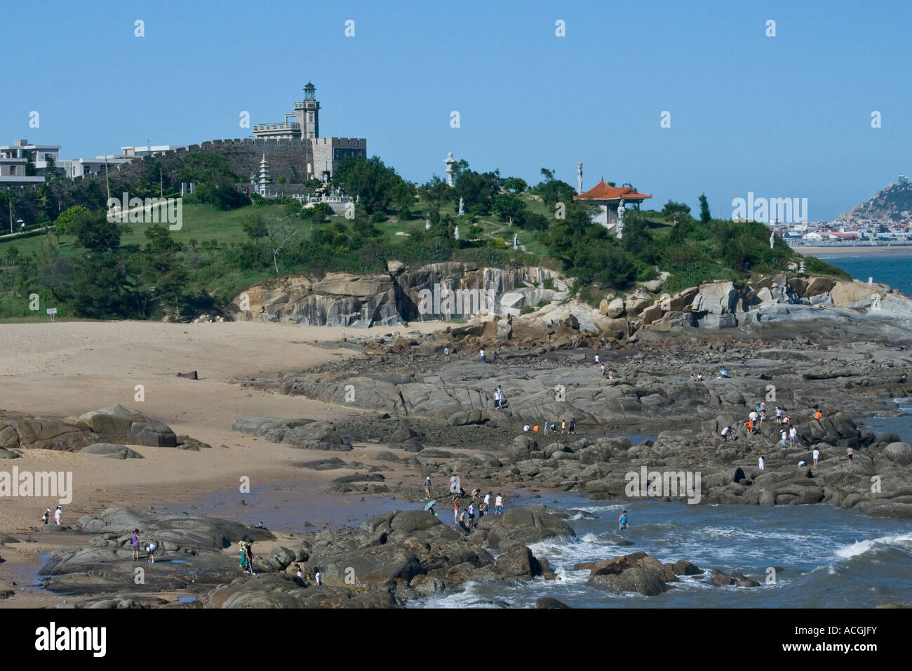 Le persone che si godono la spiaggia e l'acqua dell'oceano al di fuori della antica città murata di Chungwu provincia del Fujian in Cina Foto Stock