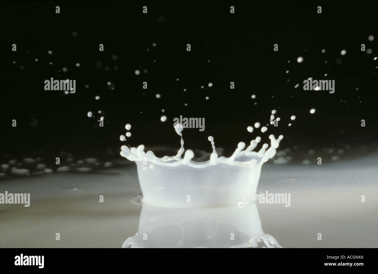 Una corona formata da una goccia di latte schizzare su una superficie di vetro Foto Stock