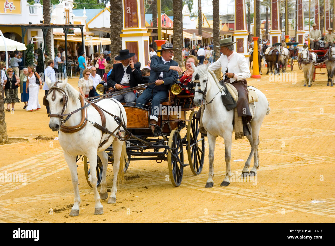 Impeccabilmente vestito persone locali incontrare e salutare a Jerez de la Frontera Fiera Cavalli Rider sulla razza spagnola cavalli andalusi Foto Stock