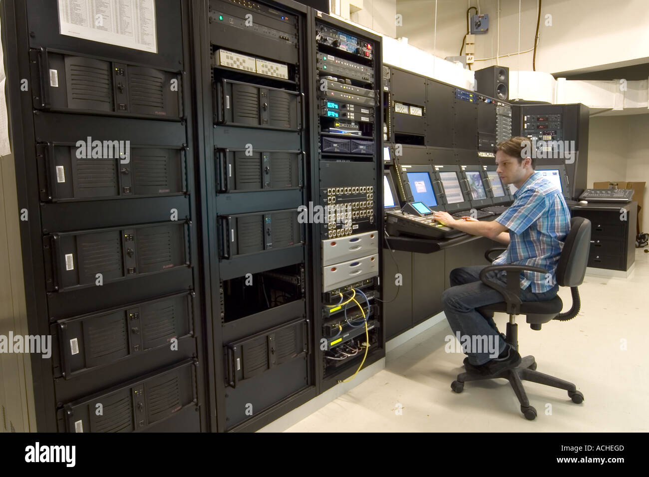 L'uomo maschio seduta a high tech audio visivo ponte di comando AV in sala di controllo Foto Stock