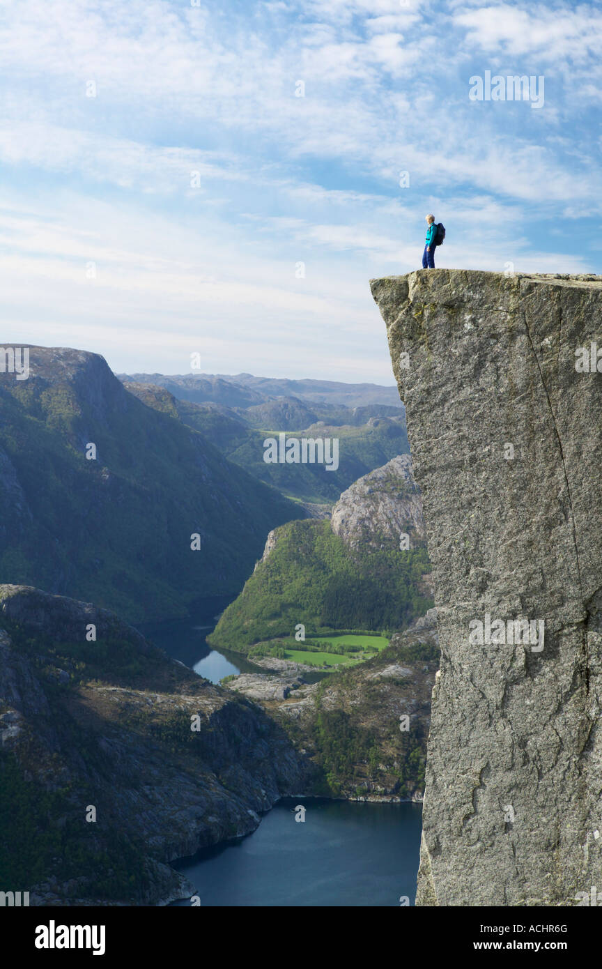 Walker in piedi sul Prekestolen, pulpito o roccia, sopra Lysefjorden, Forsand, Rogaland, Norvegia. Foto Stock