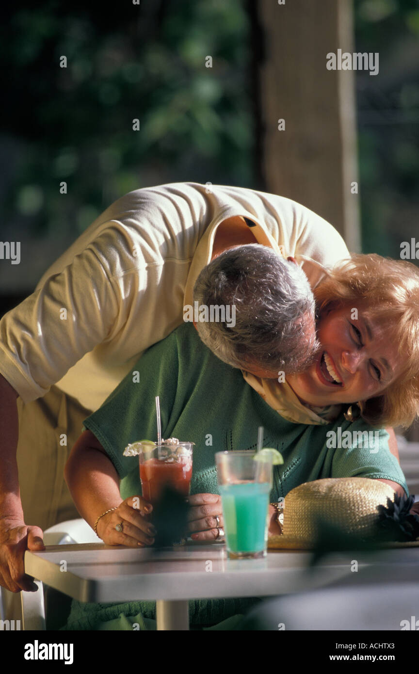 Senior nuzzling uomo donna in outdoor cafe Foto Stock