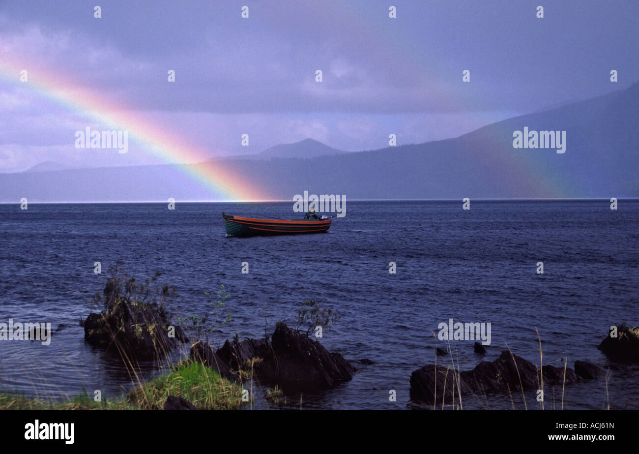 La pesca al di sotto di un arcobaleno su Muckross Lake, nel Parco Nazionale di Killarney. Contea di Kerry, Irlanda. Foto Stock