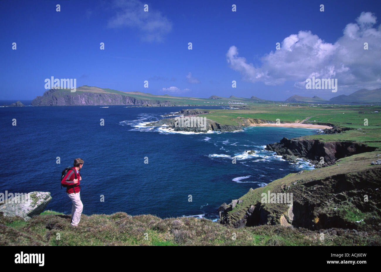 Walker guardando verso Clogher Spiaggia dalla testa di Clogher. Penisola di Dingle, nella contea di Kerry, Irlanda. Foto Stock