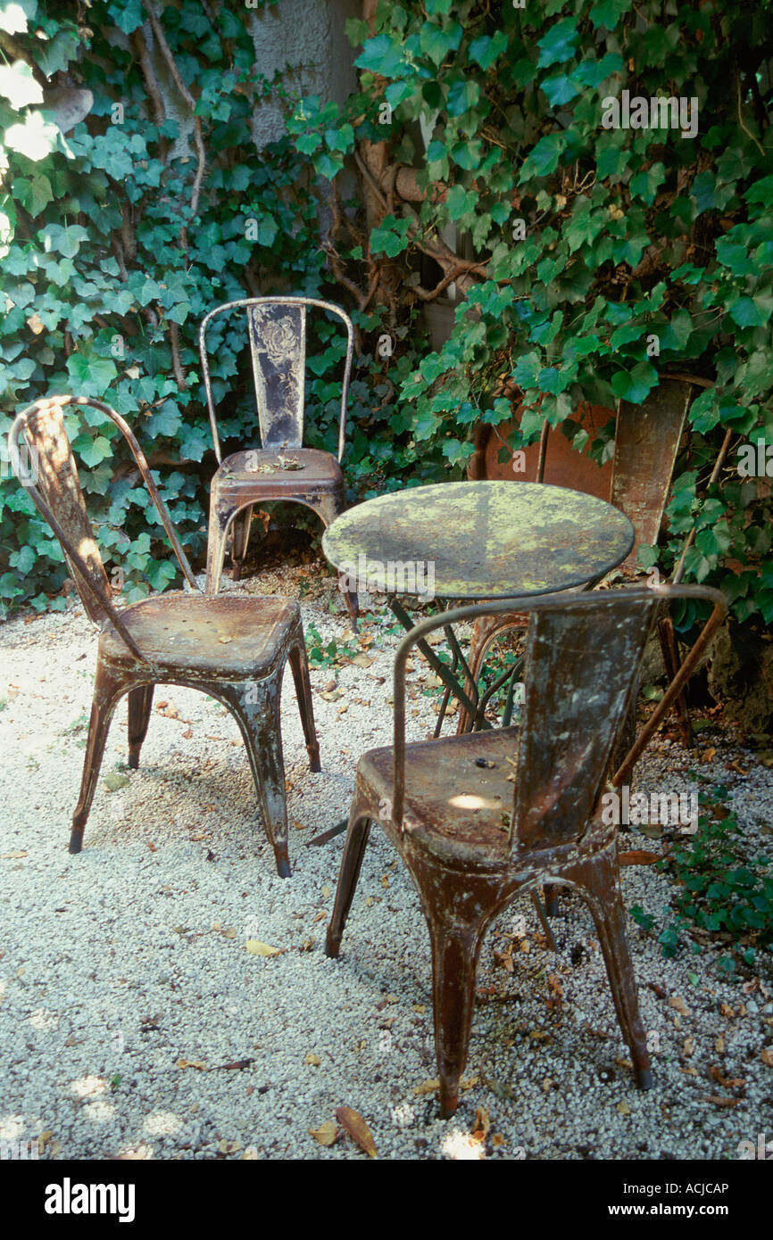 Sedie da giardino tavolo arrugginita ghiaie sul pavimento ivy sulla parete  Foto stock - Alamy