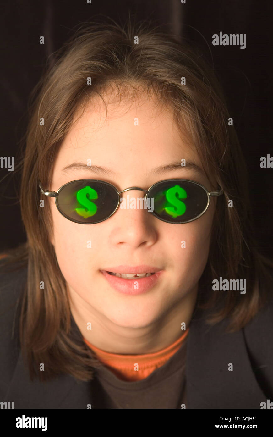 Un ragazzo adolescente indossando occhiali da sole con segni di dollaro sulle lenti Foto Stock