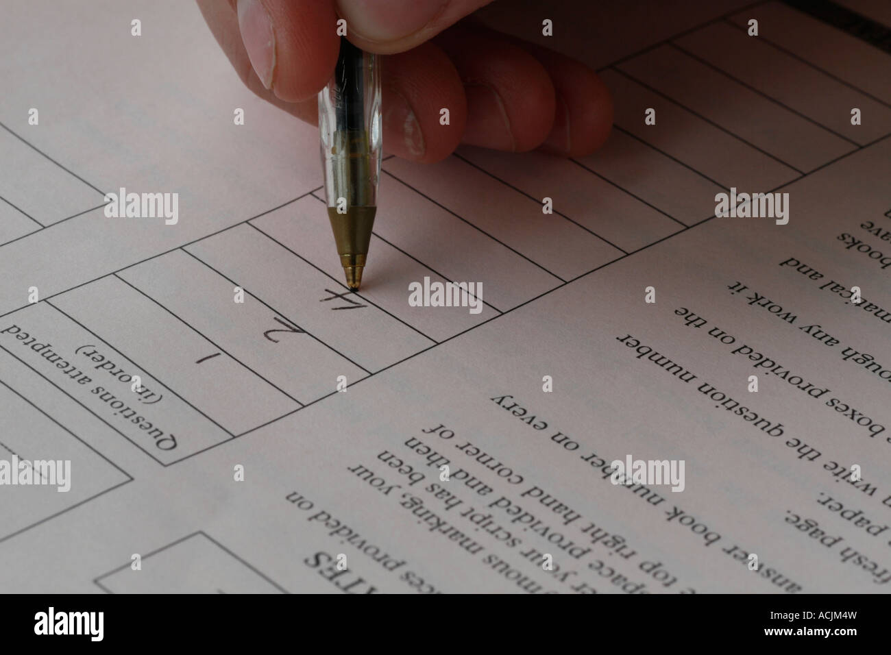 Una vista ravvicinata di uno studente di completare un esame carta utilizzando un nero penna a sfera Foto Stock