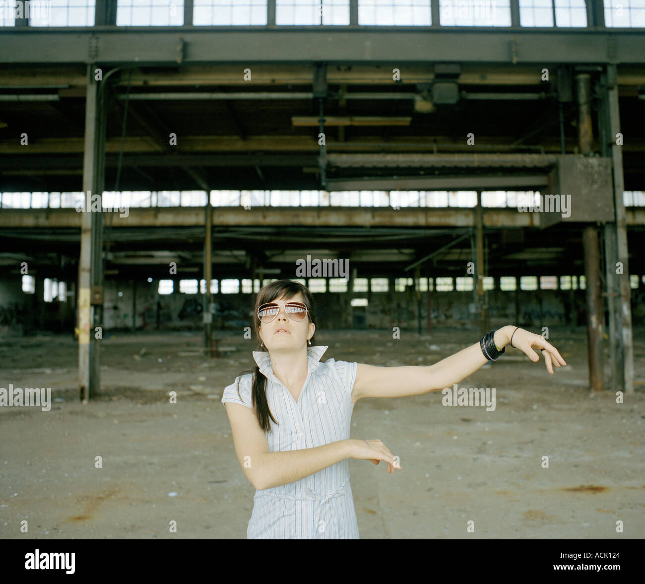 Una donna dancing di fronte a un settore industriale sito in costruzione Foto Stock