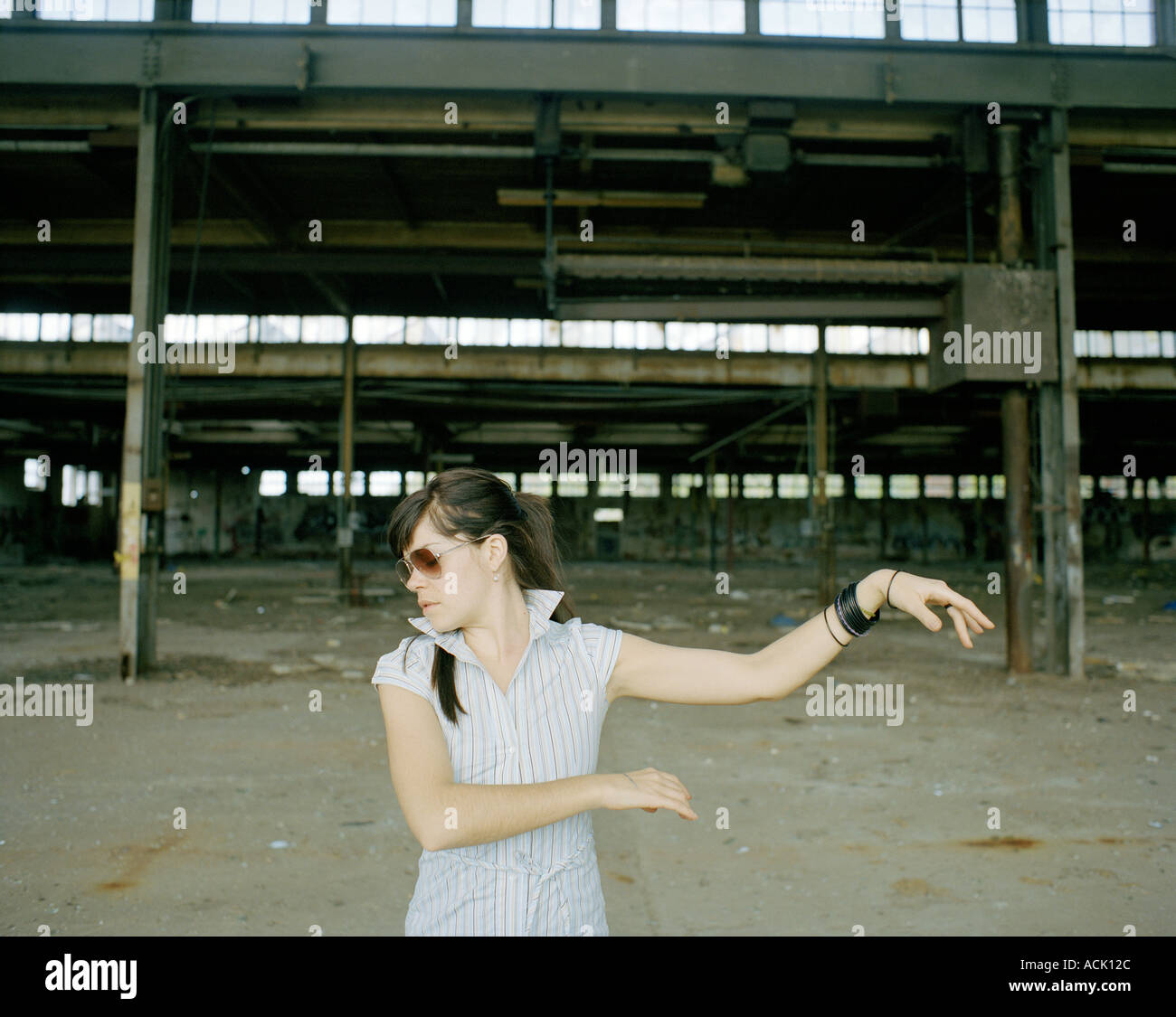 Una donna dancing di fronte a un settore industriale sito in costruzione Foto Stock
