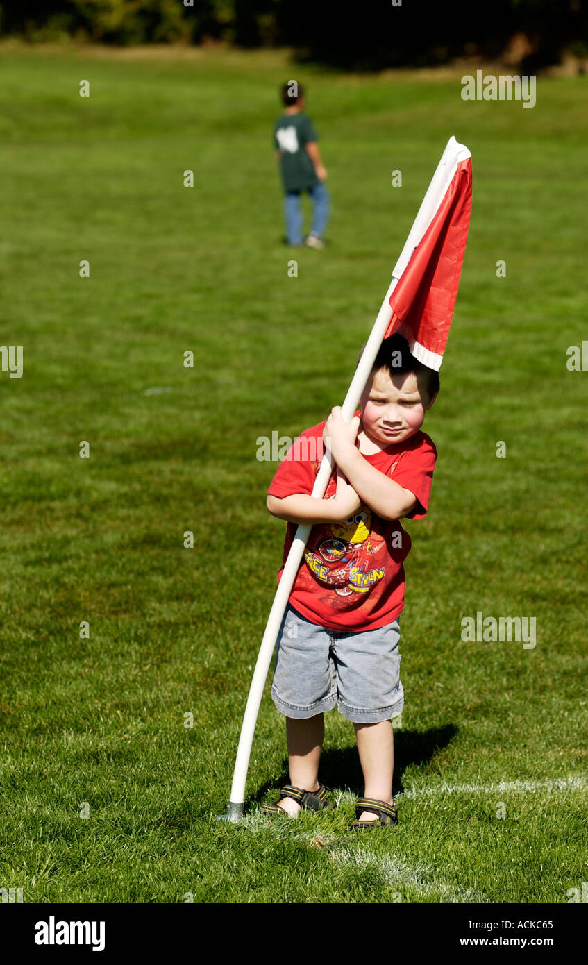 3 anno vecchio ragazzo tenendo premuto su di una bandiera rossa Foto Stock