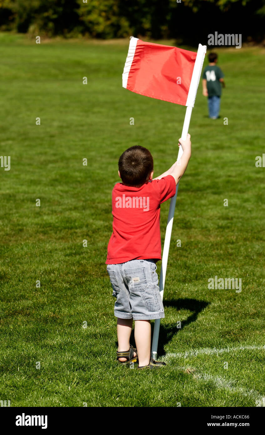 3 anno vecchio ragazzo tenendo premuto su di una bandiera rossa Foto Stock