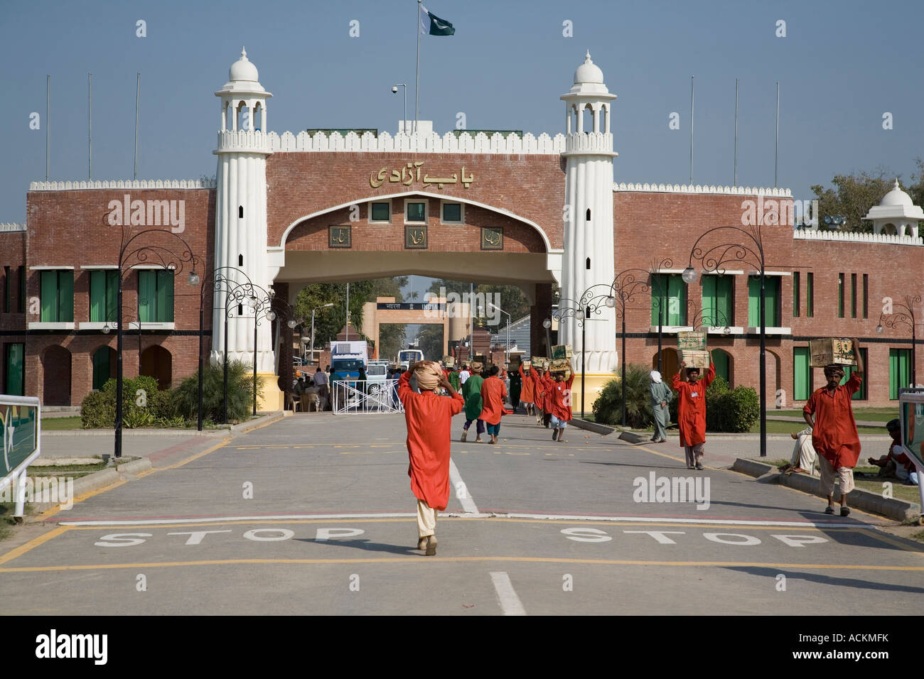 Il pakistan facchini trasportare merci attraverso il cancello Wagah, sul confine con l India Foto Stock