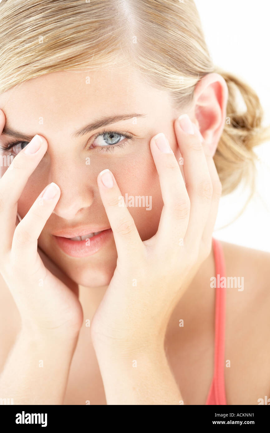 Una giovane donna si copre la faccia stretta fino Foto Stock