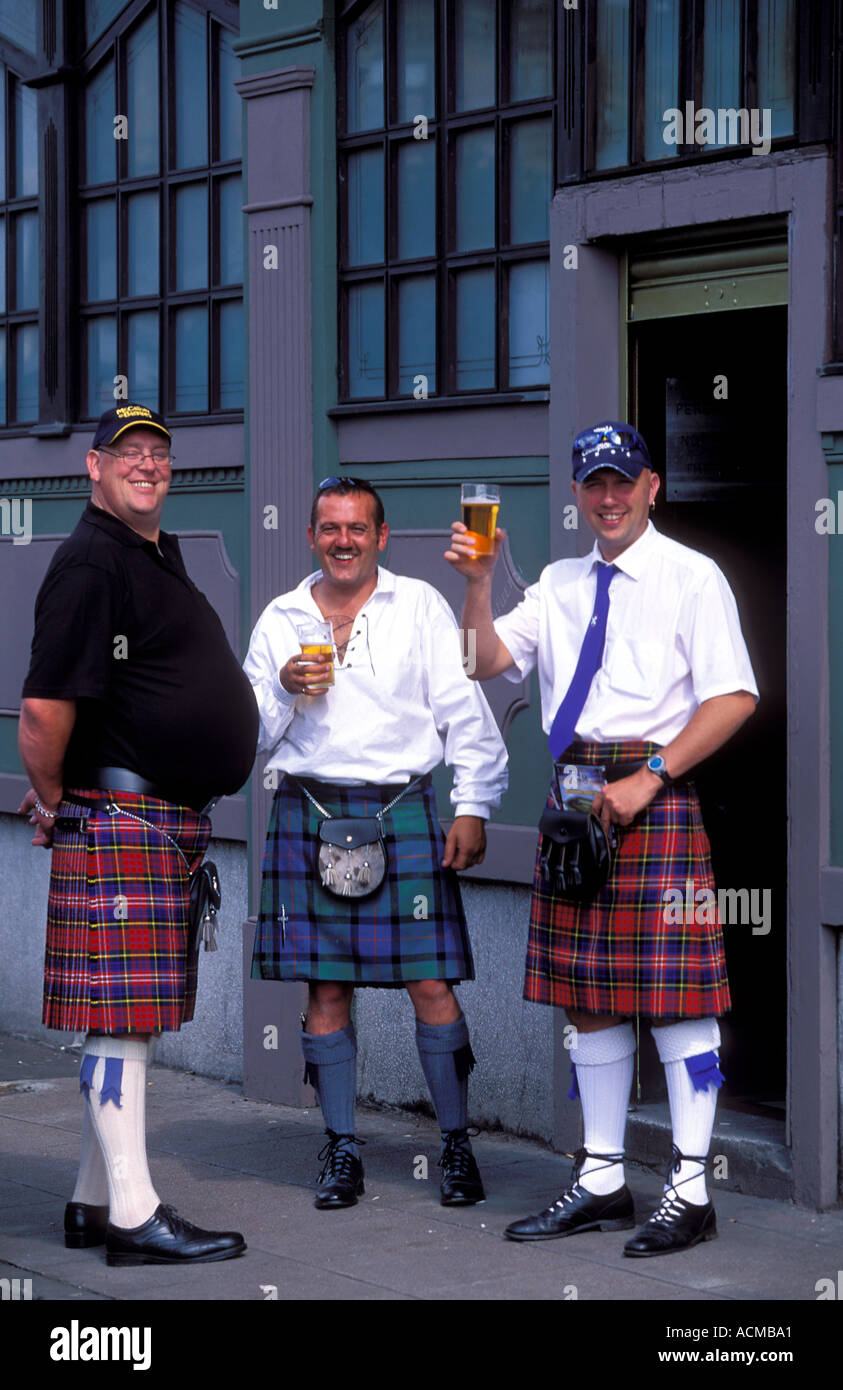Scozia Glasgow Scottish tre uomini stavano in piedi al di fuori di un pub tradizionale che indossano kilts Foto Stock