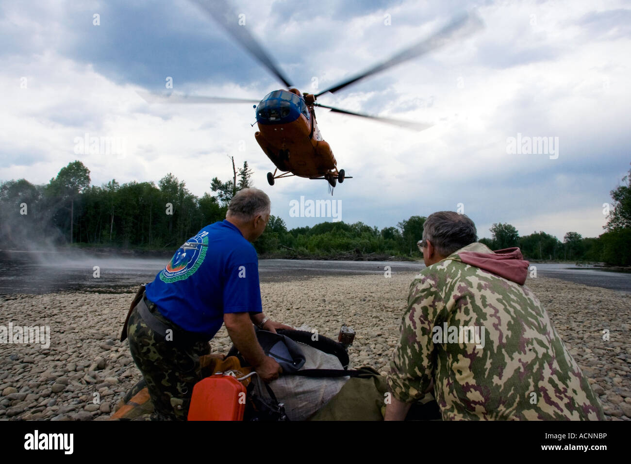 Proveniente in elicottero a ritirare il russo ponticello fumo Forest Fire Fighters vicino a un fiume in una regione remota della taiga Siberiana Foto Stock