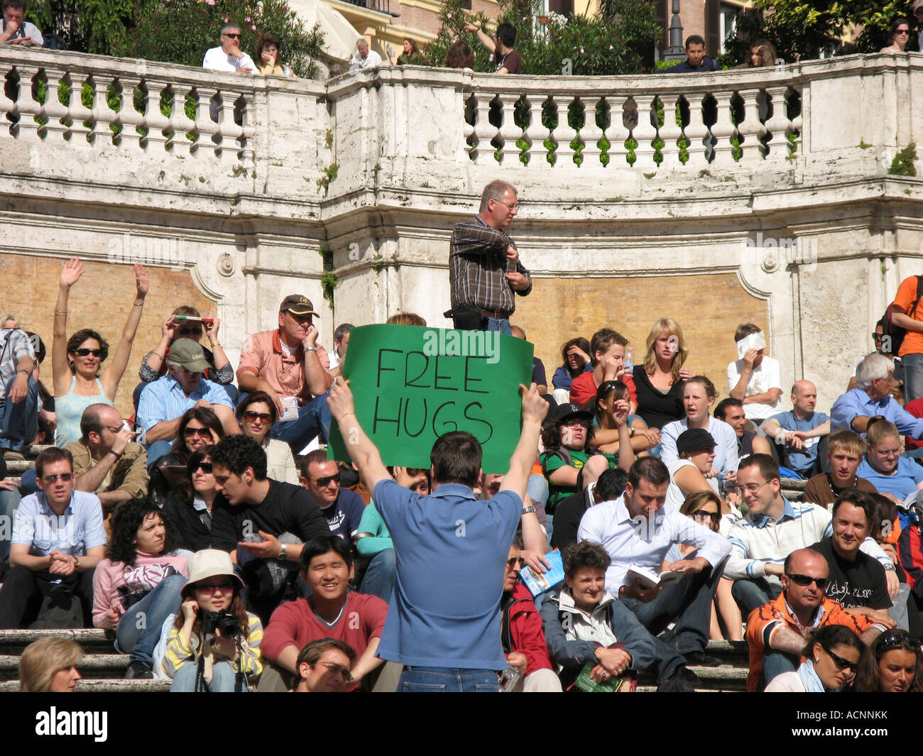 Uomo con segno dando via libera abbracci alla Scalinata di piazza di Spagna Roma Italia Foto Stock
