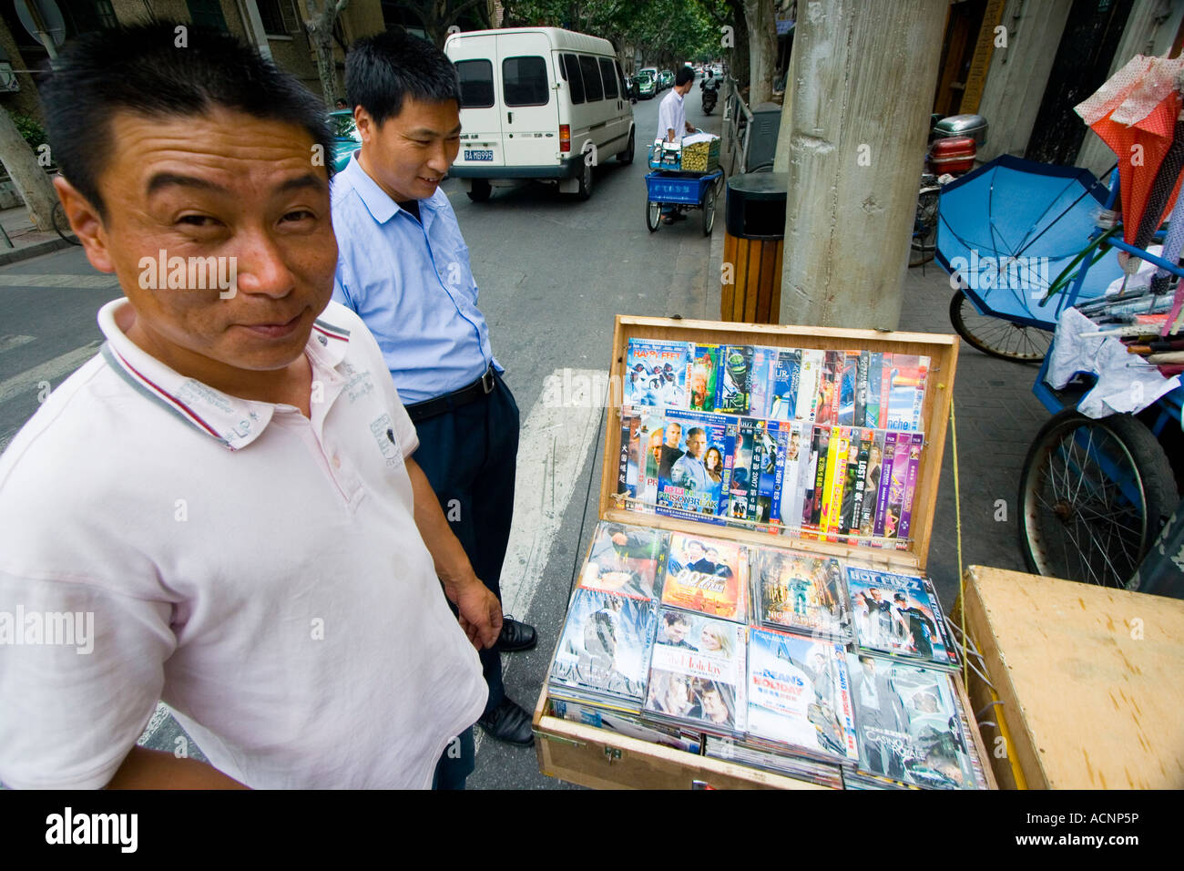 Uomo cinese di vendita falsi DVD contraffatti per strada Shanghai in Cina Foto Stock
