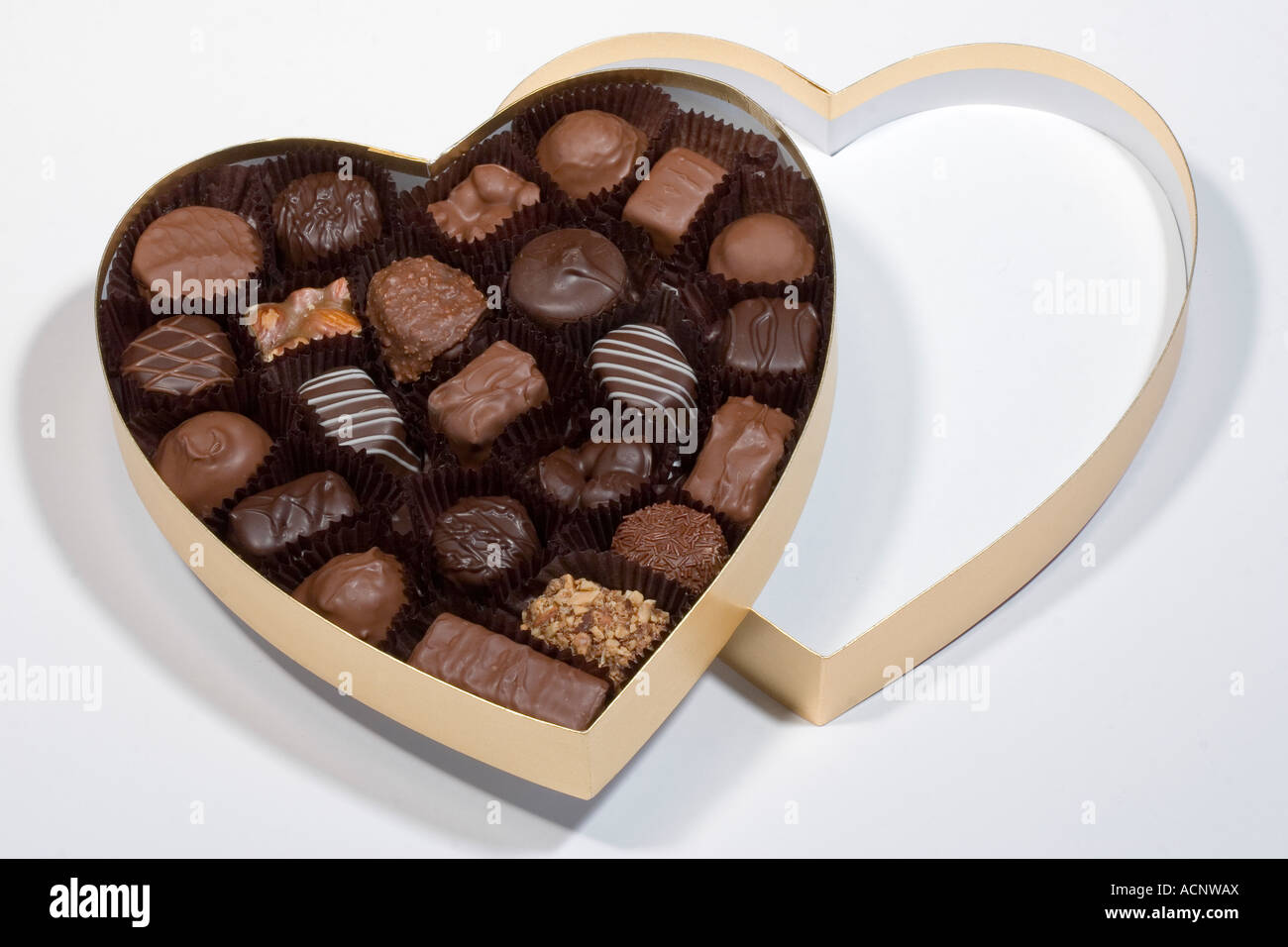 Il giorno di San Valentino dono di oro a forma di cuore ad una scatola di  cioccolatini appoggiata sulla scatola cuore top dando un doppio effetto di  cuore Foto stock - Alamy